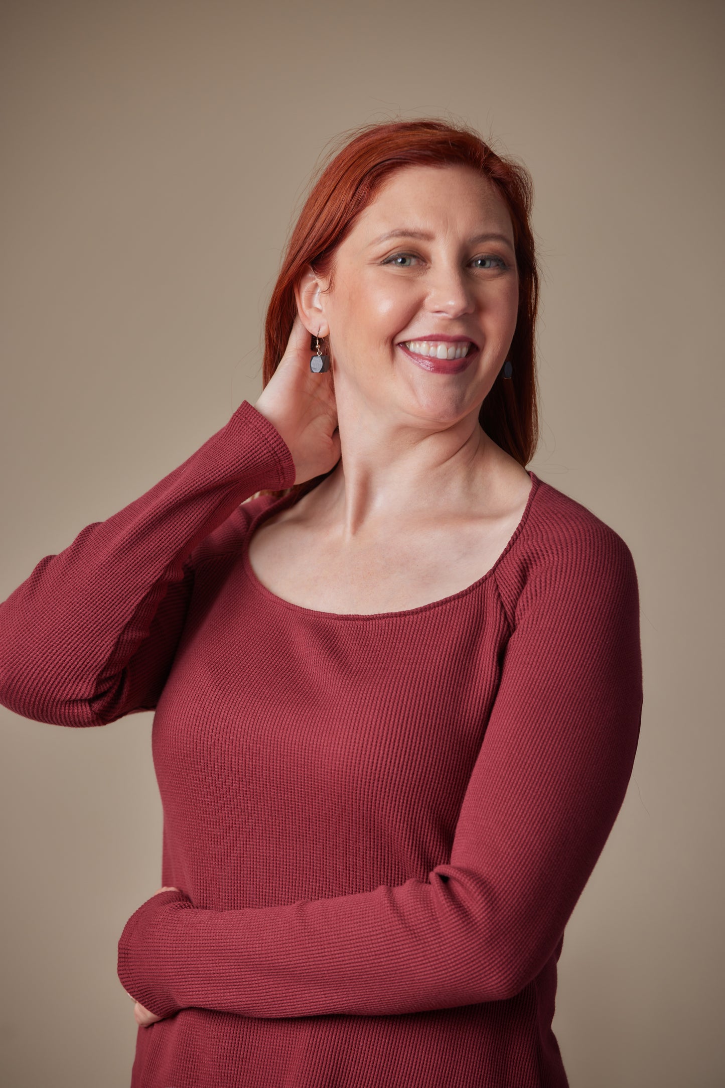 Woman wearing a red sweater against a beige background