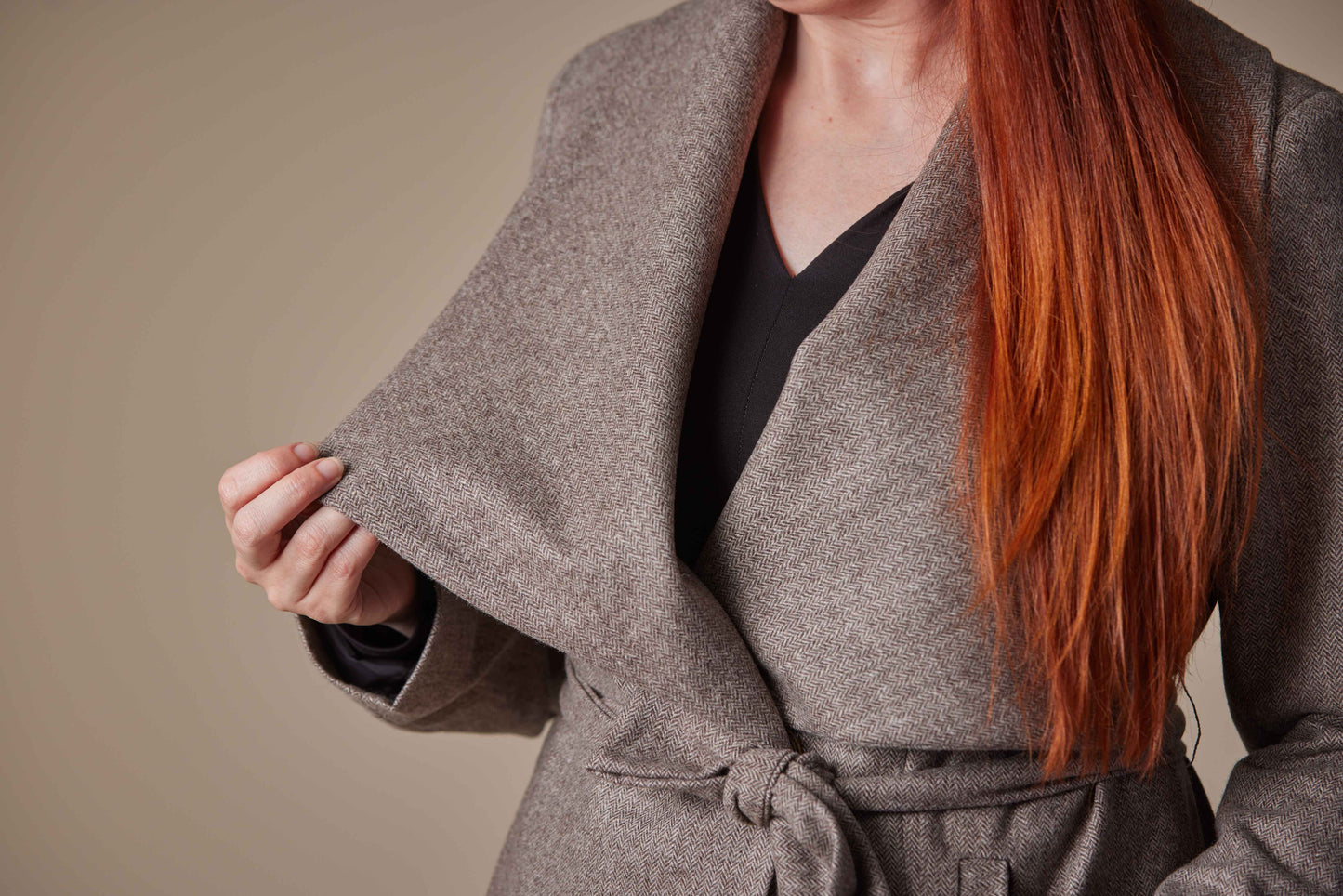 Person wearing a Brown coat with a neutral background