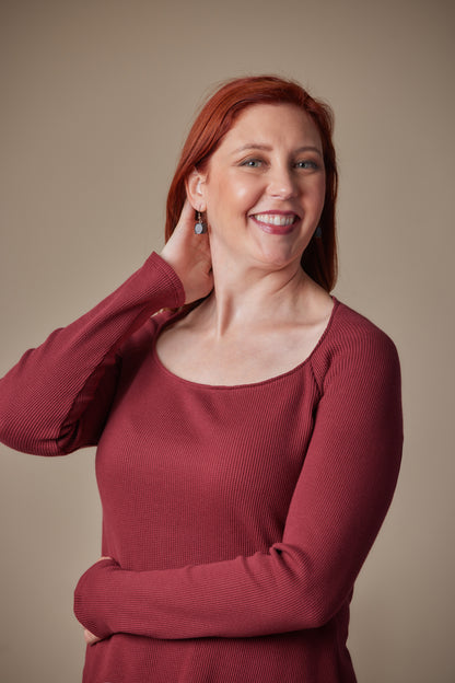 Woman wearing a red sweater against a beige background