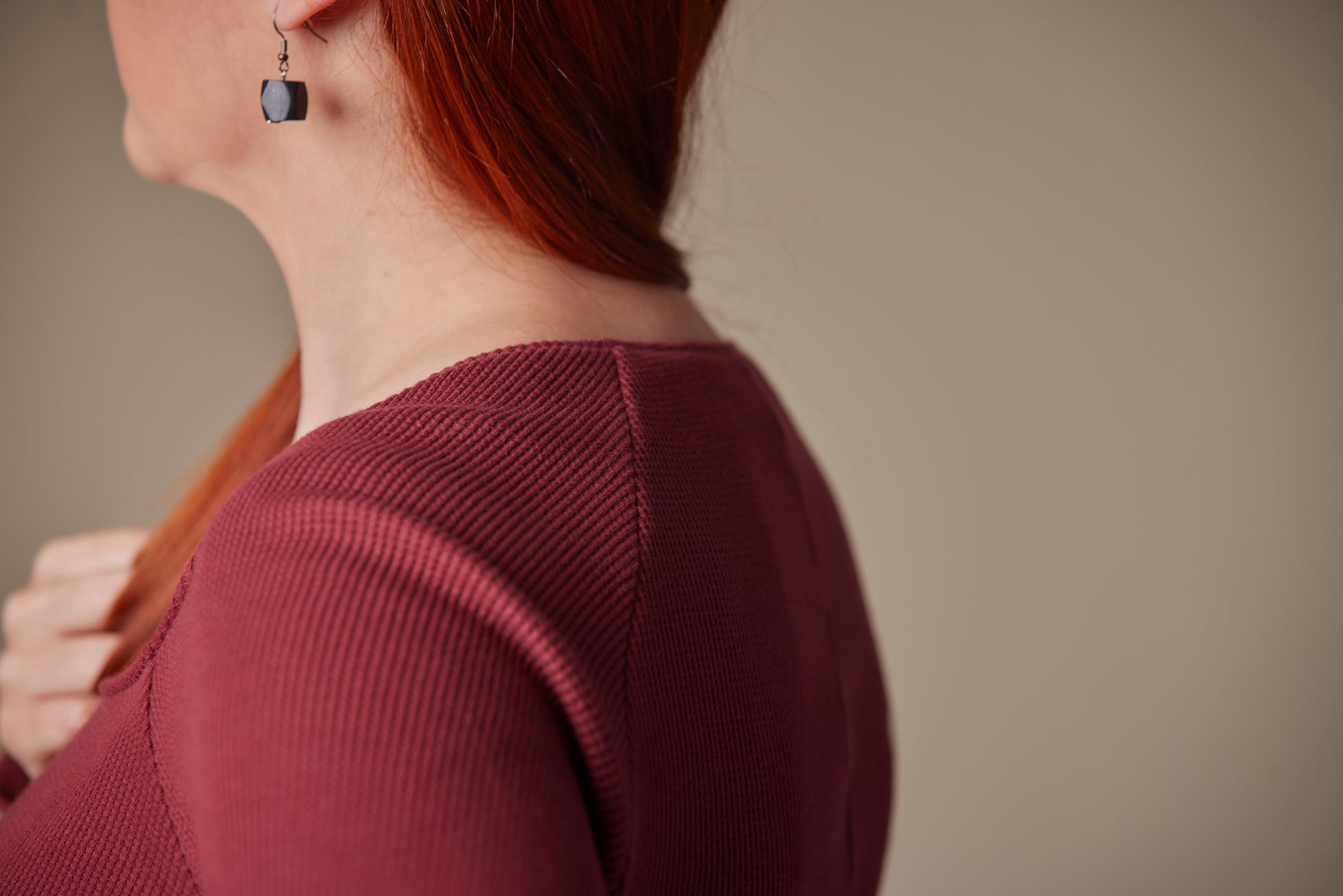 Woman wearing a burgundy sweater with a blurred background