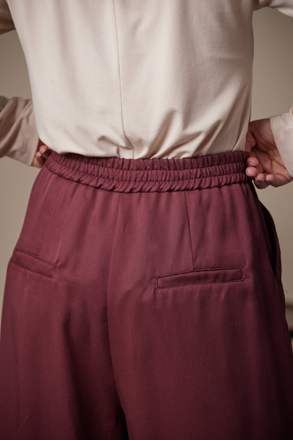 Maroon pants worn by a person with a neutral background