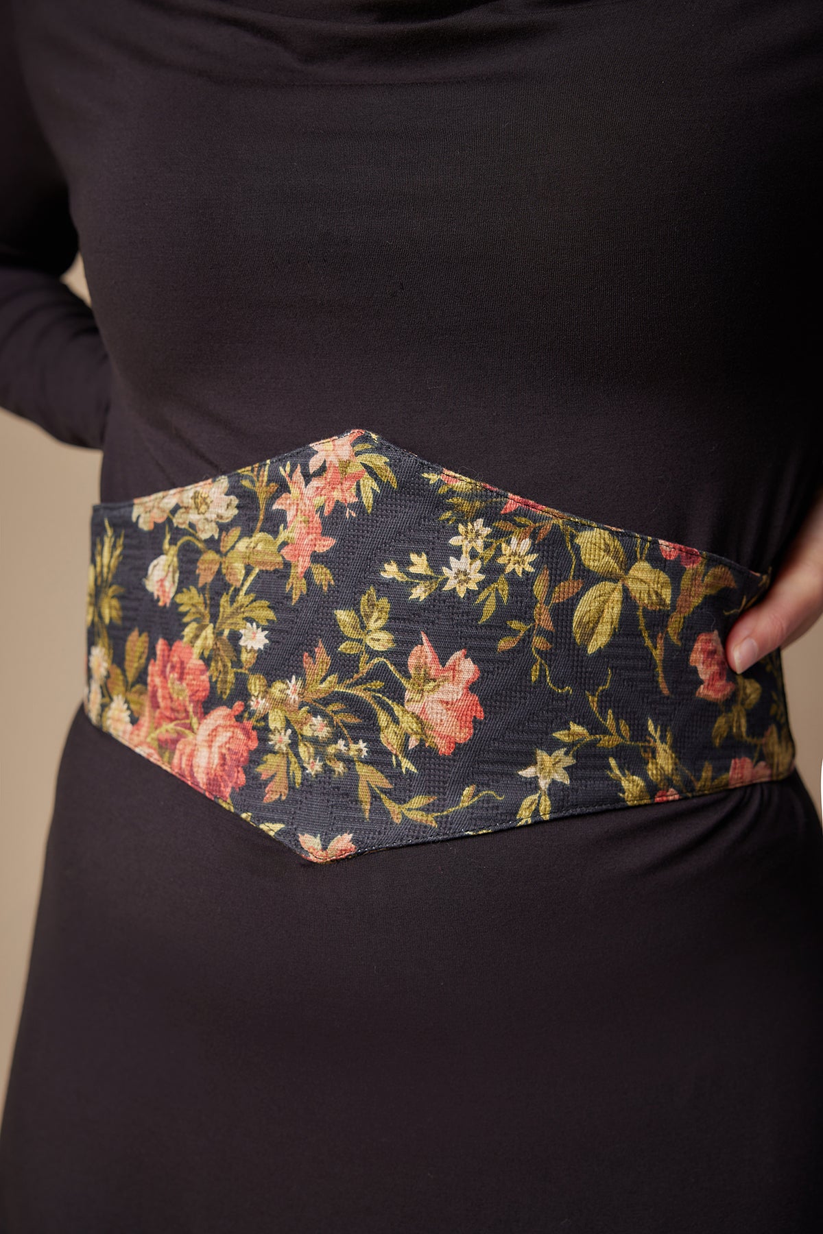 Floral belt worn by a person on a plain background