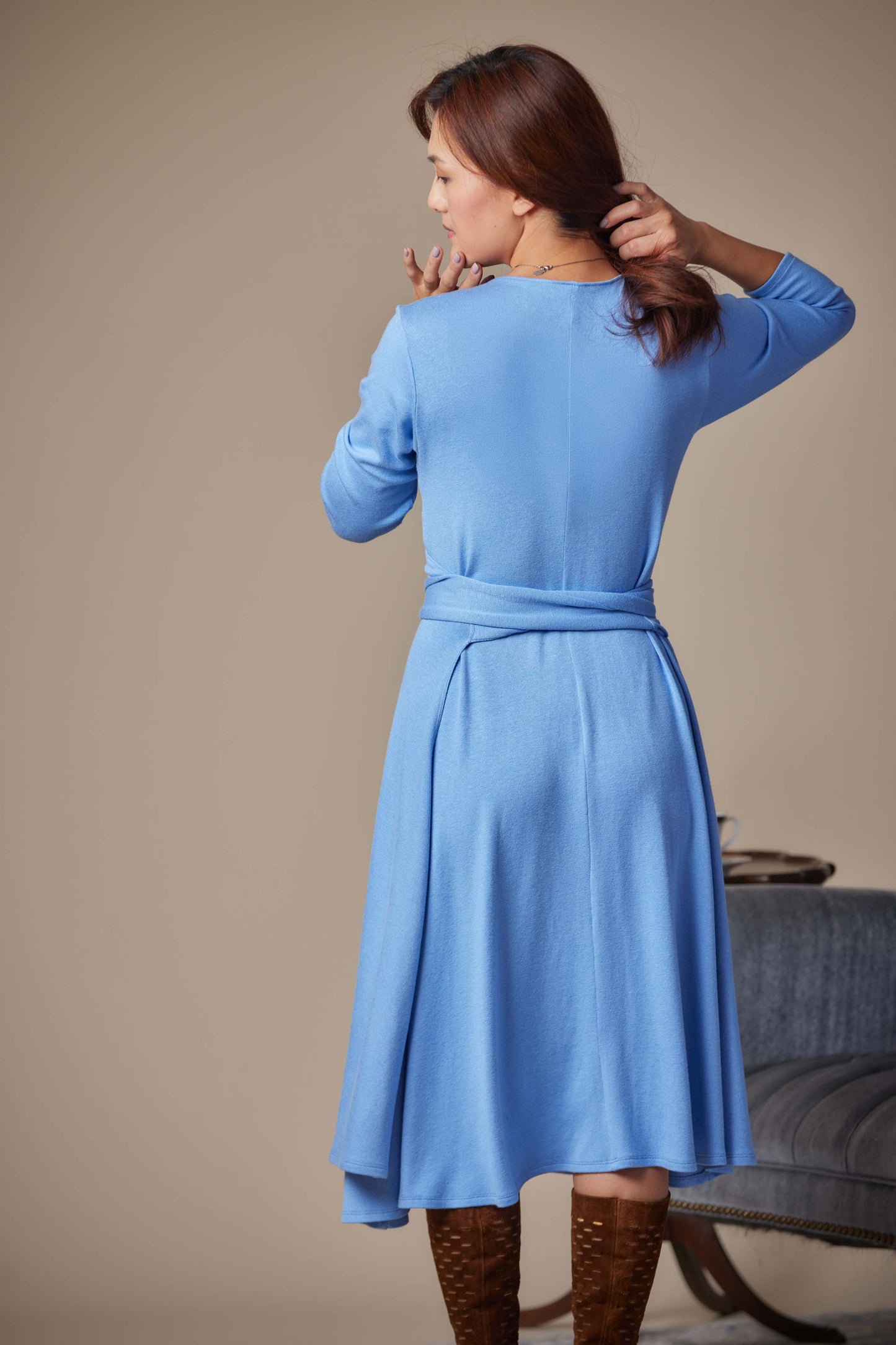 Woman wearing a blue dress with a neutral background