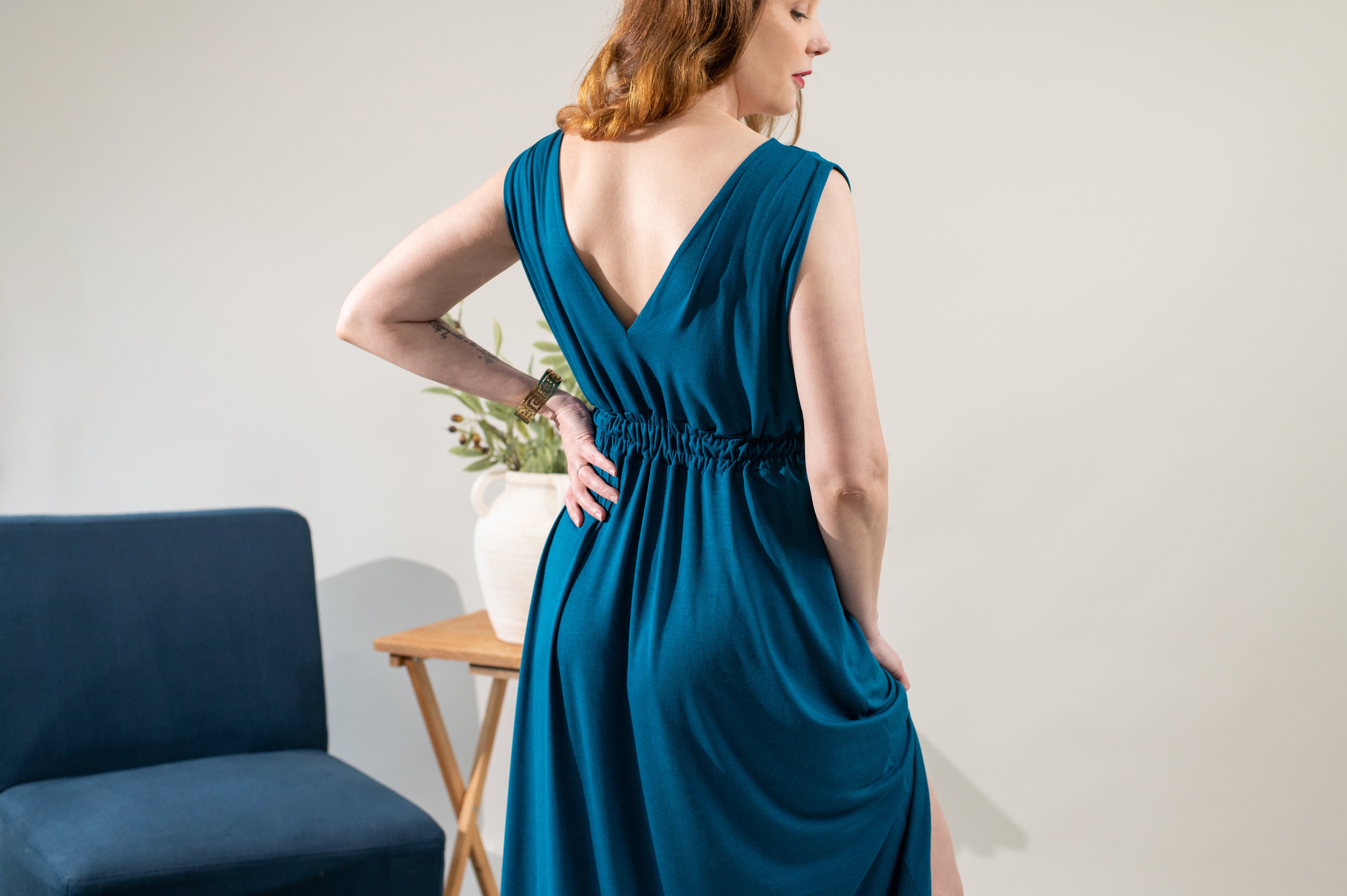 Woman wearing a teal dress with a plain background